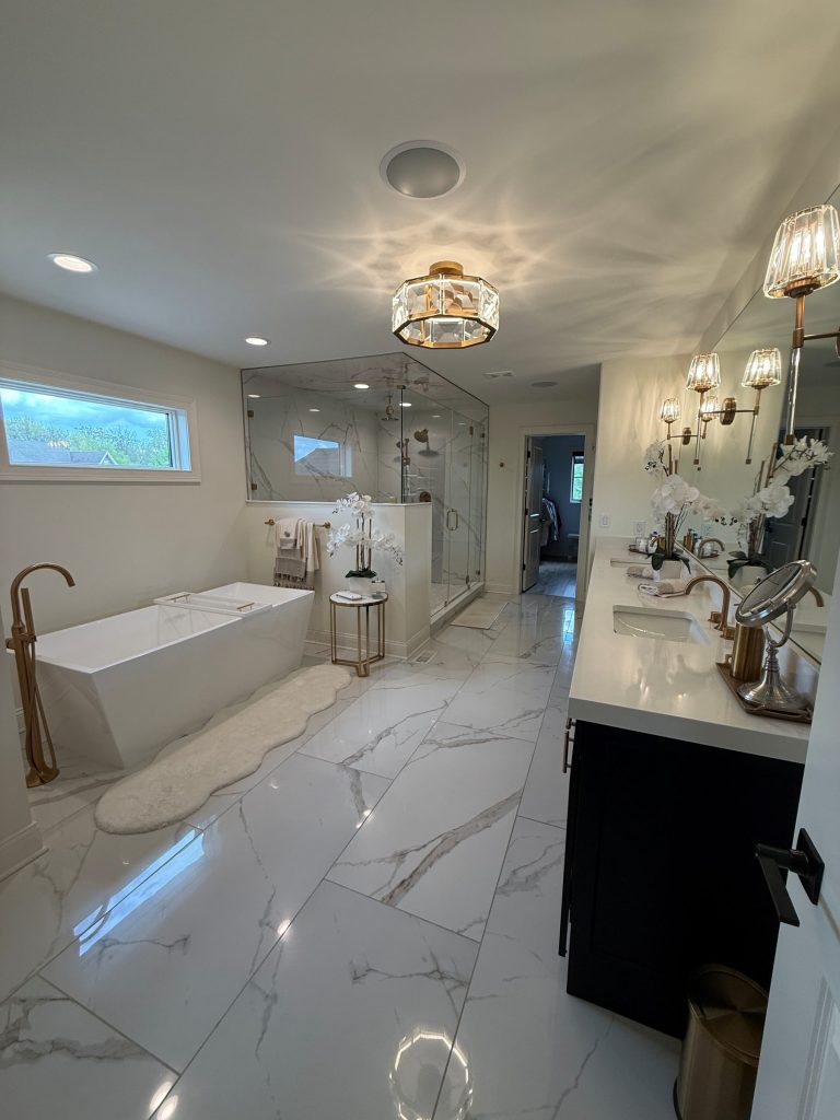 Primary bathroom with freestanding tub and marble-look tile
