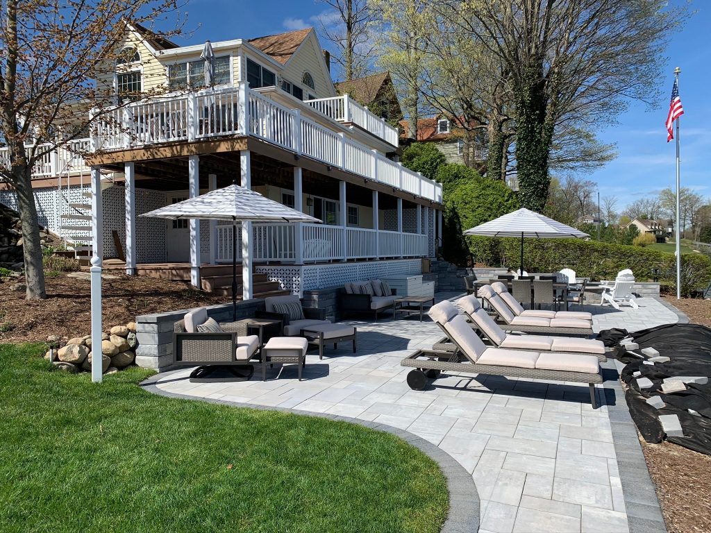 Two-level deck with white railings above a paver patio