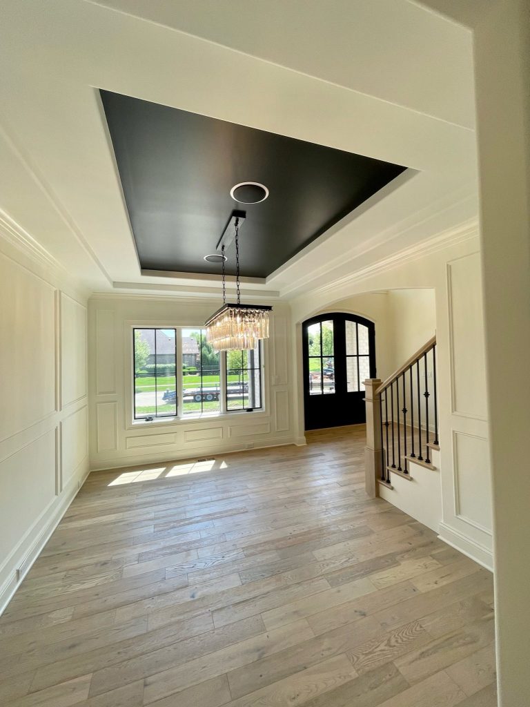 Dining room with painted tray ceiling and wainscoting