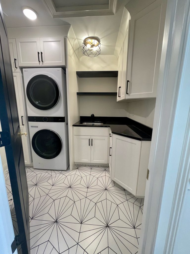 Laundry room with stacked washer-dryer and geometric tile floor